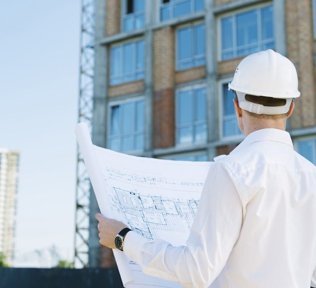 vista-traseira-homem-segurando-edificio-planos_615mmX560mm